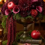 Composizione su coppa in metallo con dalie, rose, amaranthus, muschio nordico, zantedeschia, bacche e pigne decorative.